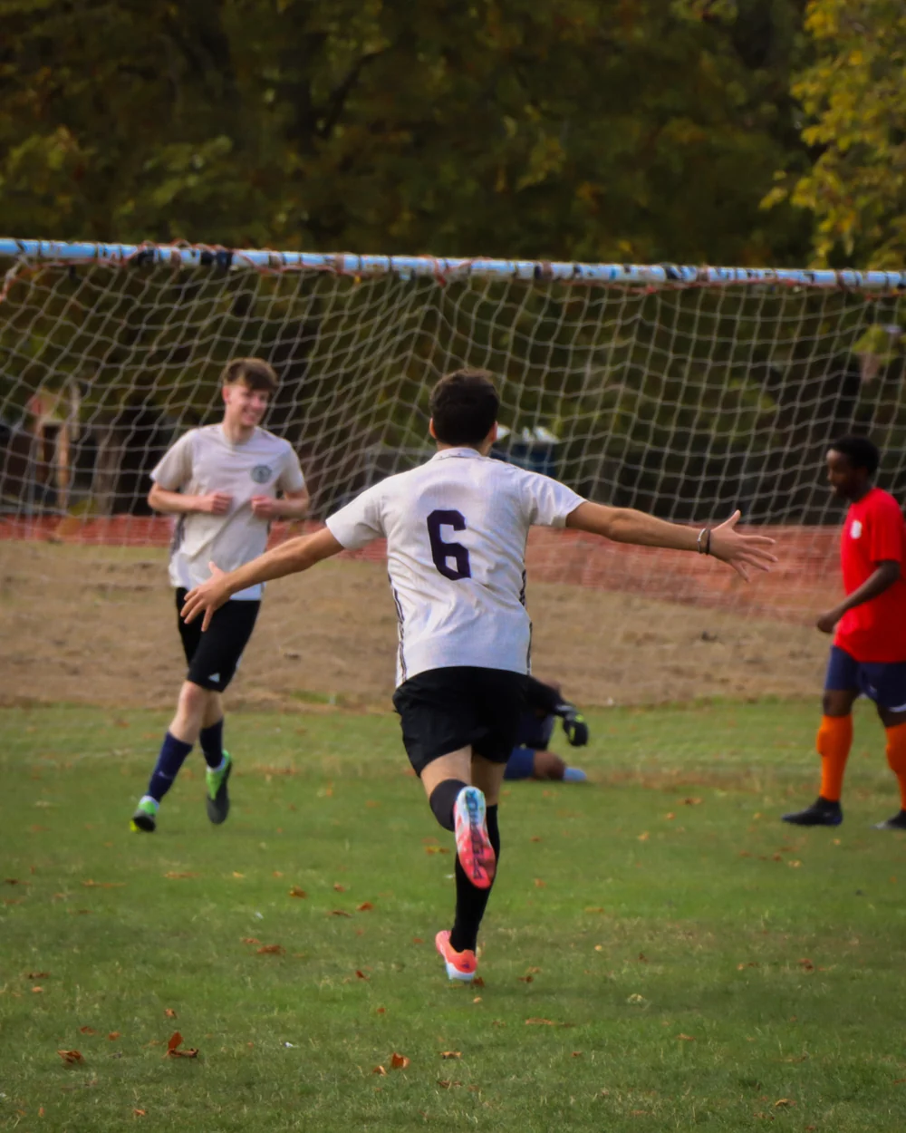 A Spartans player running to celebrate with his teammates